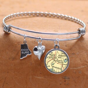 May include: A silver charm bracelet with three charms: a heart, a map of Rhode Island, and a map of Kingston, Rhode Island.