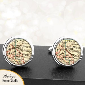 May include: A pair of silver cufflinks with a vintage map of Deadwood, South Dakota. The map shows the towns of Lead, Sturgis, and Roubaix.
