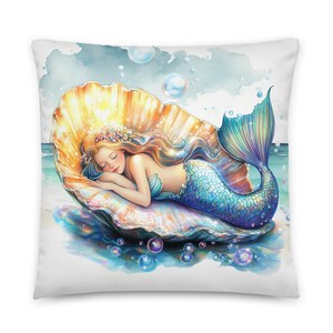 Cojín decorativo con diseño de la Sirena de La Bella Durmiente descansando sobre una concha marina, ideal para sofá, silla o decoración del hogar. Incluye relleno. Estilo náutico y costero.