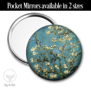 Könnte beinhalten: Ein runder Taschenspiegel mit silbernem Rahmen und einem blauen und weißen Bild eines blühenden Mandelbaums. Das Bild ist eine Reproduktion eines berühmten Gemäldes von Vincent van Gogh.