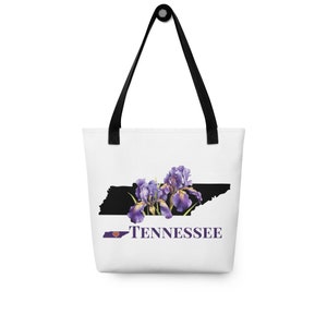 May include: White tote bag with a black silhouette of the state of Tennessee with purple iris flowers and the text "I love Tennessee" in purple.