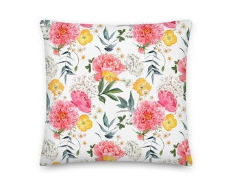 May include: A white pillow with a floral pattern featuring pink and yellow flowers on a white background.