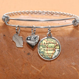 Puede incluir: Un brazalete de plata con tres dijes: un corazón, un contorno del estado de Wisconsin y un mapa vintage del área de Appleton, Wisconsin.