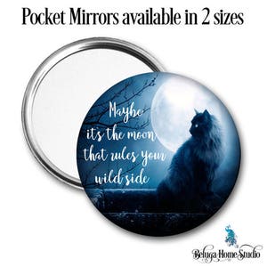 Puede incluir: Espejo de bolsillo redondo con marco plateado. El espejo muestra una silueta de gato negro contra una luna llena y el texto "Maybe it's the moon that rules your wild side."