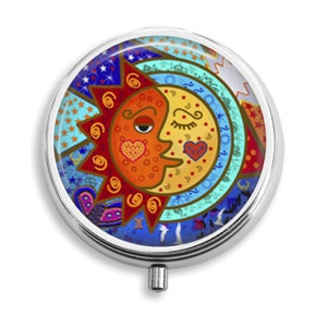 Puede incluir: Una caja de píldoras redonda de plata con un diseño colorido de un sol y una luna con corazones. El sol es naranja y rojo, la luna es amarilla y azul, y el fondo es una mezcla de azul, verde y rojo.