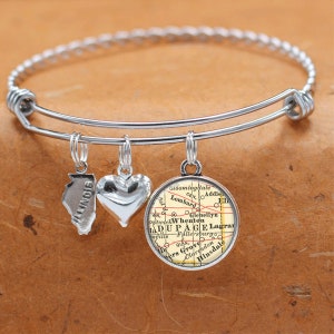 May include: A silver charm bracelet with three charms: a heart, a state of Illinois outline, and a vintage map of DuPage County, Illinois.