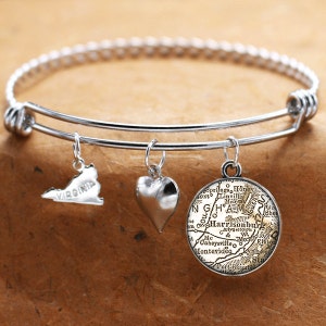 May include: A silver expandable bangle bracelet with three charms: a heart, a map of Virginia, and a vintage map of Harrisonburg, Virginia.