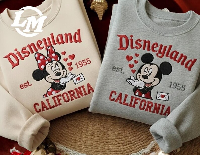 Two sweatshirts with the Disney theme park logo and text, featuring Minnie Mouse and Mickey Mouse.