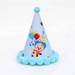 May include: A light blue party hat featuring a cartoon clown, the number 1, and balloons. The hat has a light blue pom-pom trim and a matching pom-pom on top. A festive birthday accessory.