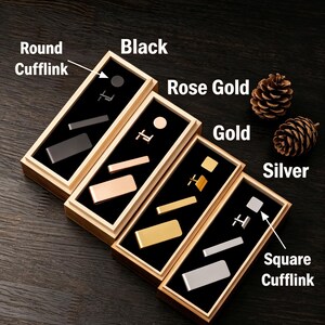 May include: Cufflink sets in black, rose gold, gold, and silver, each displayed in a wooden box with a black interior. The sets include round and square cufflinks, and tie bars. Two pinecones are placed on the dark wood surface.