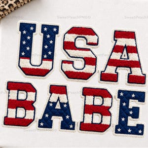 May include: White fabric with the words "USA BABE" in red, white, and blue embroidered letters. The letters are designed to resemble a varsity jacket patch, with a star pattern on the blue letters.