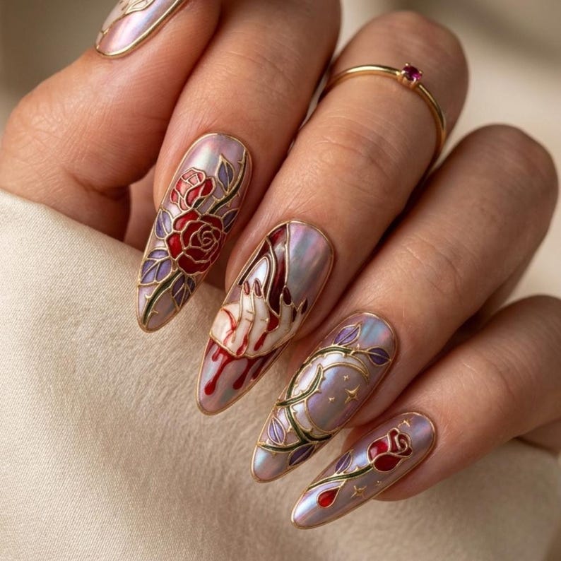 May include: Close-up of long, almond-shaped nails with intricate designs. The nails feature a pearlescent base with detailed artwork of roses, vines, and a hand with red accents. A gold ring with a red stone is also visible.