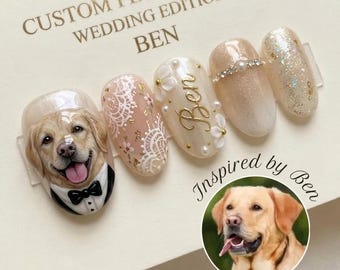 May include: A set of five press-on nails featuring a golden retriever in a tuxedo, white lace patterns, the name Ben in gold script with floral accents, a pearl-adorned nail, and a gold glitter nail, displayed on a card labeled Custom Pet Portrait.
