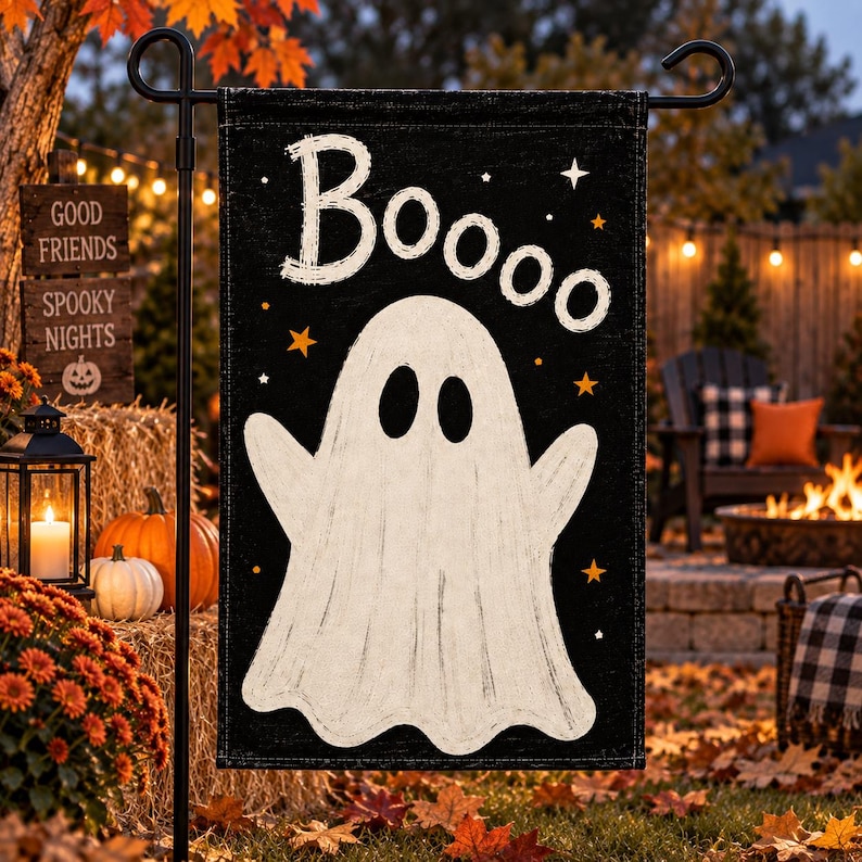 May include: A rectangular garden flag with a black background featuring a large white ghost in the center. The word "Booooo" is printed in white at the top. Small orange and white stars are scattered across the black fabric of the flag.