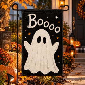 May include: A rectangular black garden flag featuring a large white ghost illustration in the center and the text "Boooo" in white at the top. The design includes small orange and white stars scattered across the black background.
