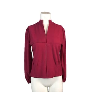 May include: A long-sleeved, magenta colored, collared cardigan with a V-neckline.