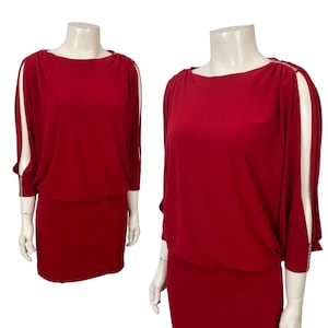 May include: A red dress with a boat neckline and elbow-length sleeves. The sleeves have a split design with white lining. The dress has a fitted skirt and a gathered waist. Rhinestones adorn the shoulders and sleeve cuffs.