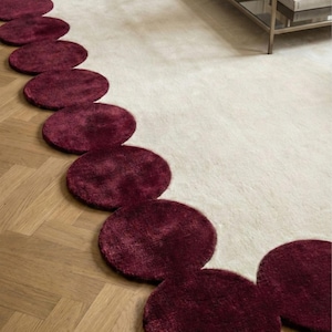 Designer statement rug 8x10 featuring wine red rounded contours and soft wool pile. The handcrafted texture, paired with the airy ivory tone, complements modern sofas and curated interiors. A perfect blend of art and functionality for luxury home decoration.