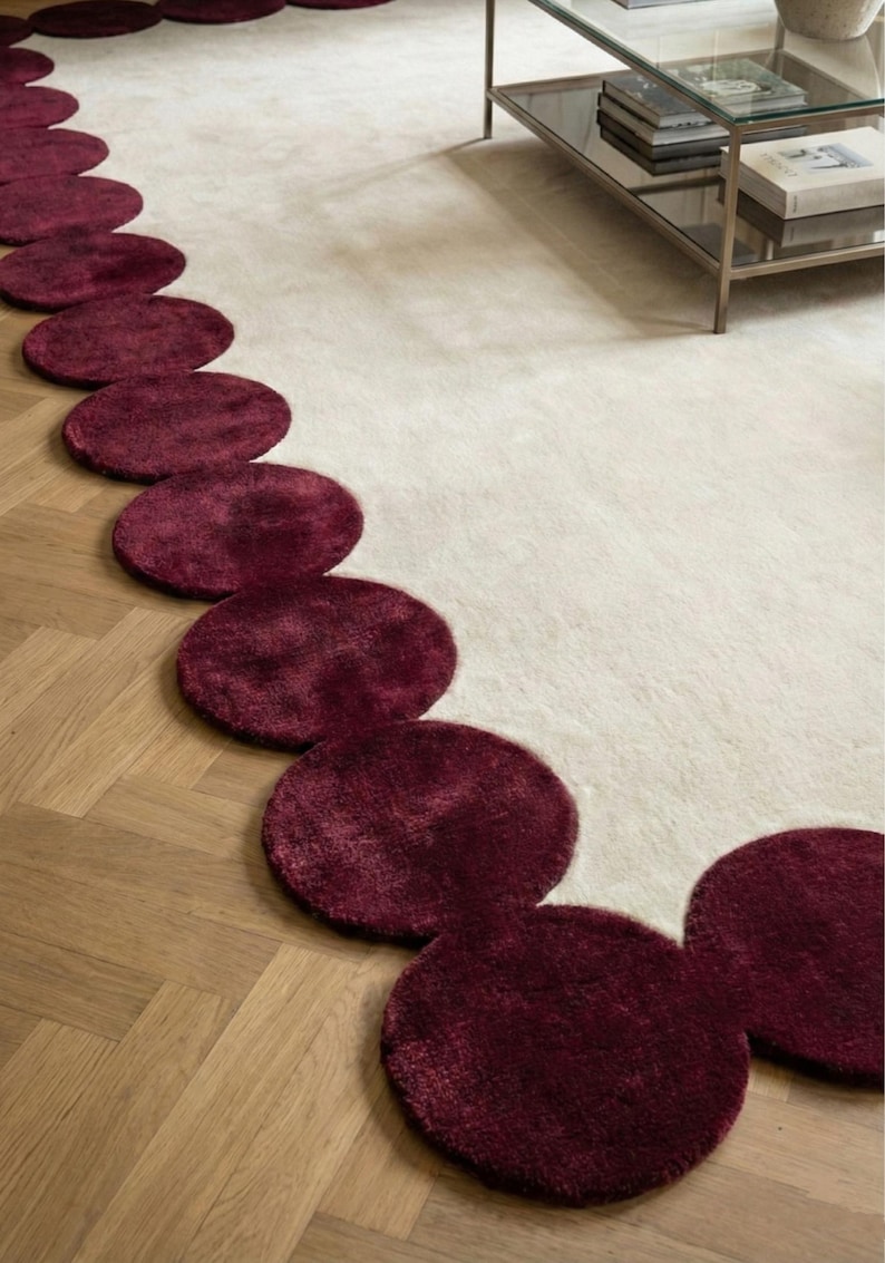 Designer statement rug 8x10 featuring wine red rounded contours and soft wool pile. The handcrafted texture, paired with the airy ivory tone, complements modern sofas and curated interiors. A perfect blend of art and functionality for luxury home decoration.