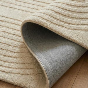 Luxury hand tufted rug 8x10 in neutral cream shade with artistic line design. Thick wool pile provides a soft underfoot feel while maintaining durability for daily use. Perfectly suited for minimalist, modern, or Japandi home styling. Works beautifully beneath coffee tables, sectionals, or beds, bringing warmth, balance, and visual interest to living rooms and bedrooms.