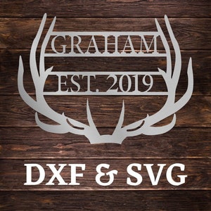Peut inclure: Une plaque en métal argenté avec un motif d'antenne de cerf. La plaque porte le texte "GRAHAM EST. 2019" et les mots "DXF & SVG" sous les bois.