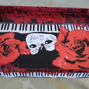 May include: A wooden serving tray with a black background and red roses. The tray features a white piano keyboard design and a black and white mask with musical notes.