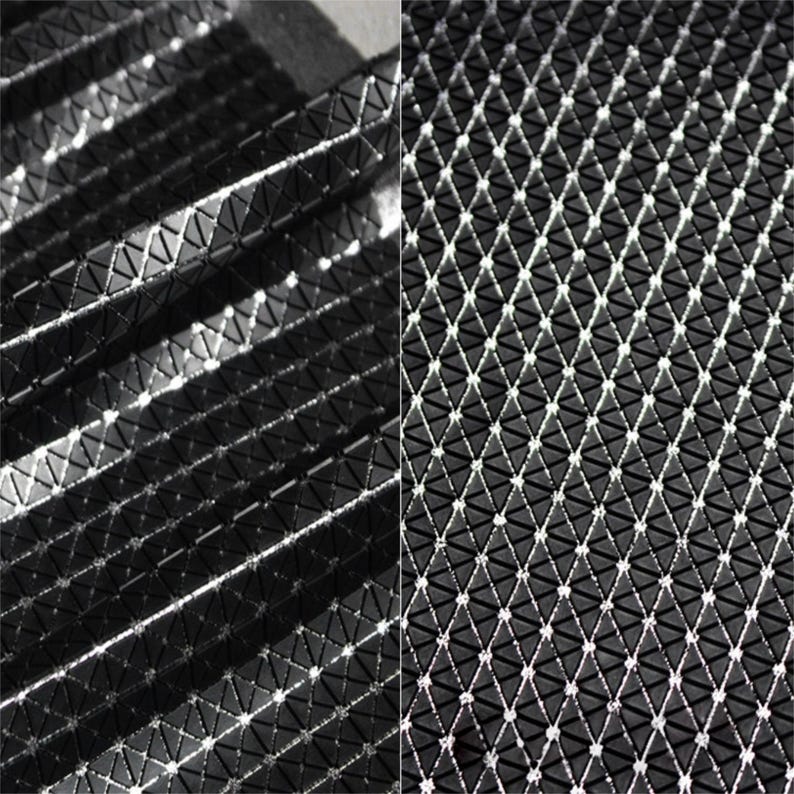 May include: A black fabric featuring a repeating geometric pattern of small, raised triangular shapes. The surface has a glossy, reflective finish that catches the light, creating a grid-like texture across the material in a structured arrangement.