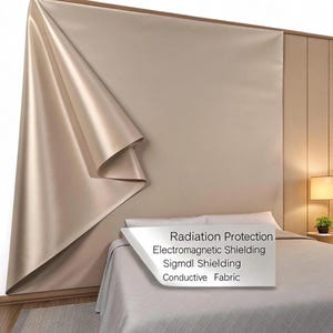 Puede incluir: Un panel de tela beige satinada cubre parcialmente una pared, revelando una sección de la pared. El texto en un letrero blanco dice: "Radiation Protection, Electromagnetic Shielding, Sigmdl Shielding, Conductive Fabric."