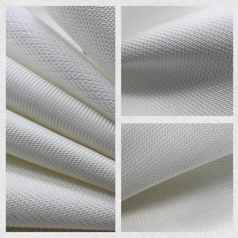 May include: Close-up of white fabric with a textured weave. The fabric is folded and layered, showcasing the detailed pattern and subtle variations in the material. The image highlights the texture and quality of the textile.