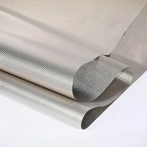 May include: A roll of light beige fabric with a subtle sheen. The fabric has a grid pattern in a darker silver color, creating a textured appearance. The material is partially rolled, revealing the underside.