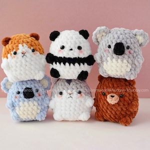 May include: A stack of six handmade crochet animal plushies. The plushies include a hamster, panda, koala, bear, and two other animal designs. Each plushie has a unique color scheme and facial features, with black safety eyes and pink cheeks.