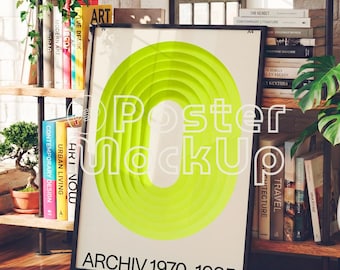 May include: A framed poster with a neon green circular design and the words "Poster MockUp" in white. The text "ARCHIV 1970-1985" is at the bottom. The poster is displayed on a wooden floor, surrounded by books and plants.