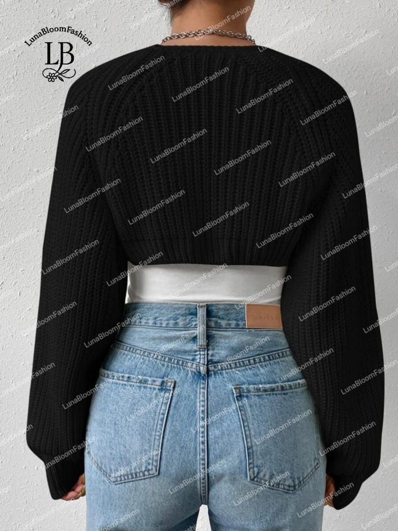 May include: A black cropped sweater with long sleeves and a round neckline. The sweater is paired with light blue denim jeans. The brand name "LunaBloomFashion" is visible in the upper left corner.