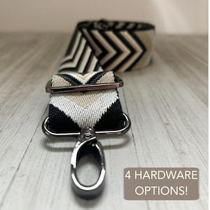May include: A black, white, and tan chevron patterned bag strap with silver-tone hardware. The strap features a metal clasp and a rectangular metal loop. The text "4 HARDWARE OPTIONS!" is displayed on a brown background.