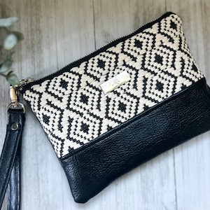 Bolso de mano o cartera de mano con correa de piel vegana negra y estampada en color crema y negro con asa extraíble