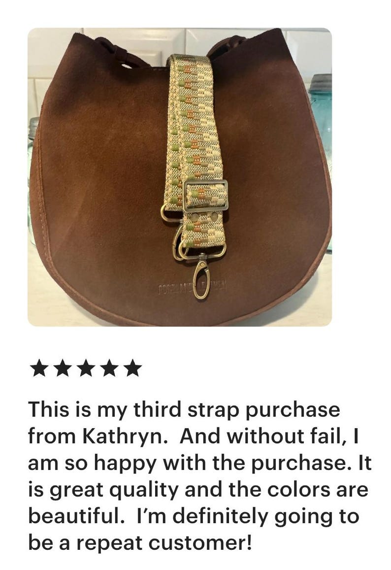 May include: A dark brown suede bag featuring a detachable woven shoulder strap. The strap displays a geometric pattern in beige, green, and orange tones, complemented by metallic hardware including a rectangular slider and a lobster clasp.