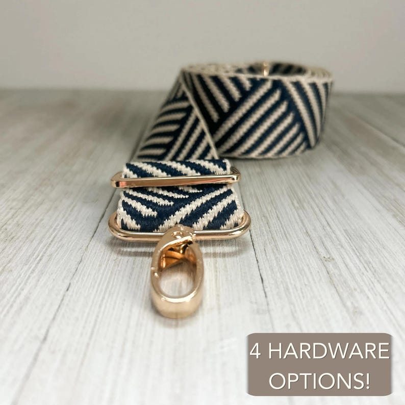 May include: A navy blue and cream woven bag strap featuring a diagonal chevron pattern. The strap includes gold-tone metal hardware with a lobster clasp and an adjustable slider. A text box in the corner reads 4 HARDWARE OPTIONS!