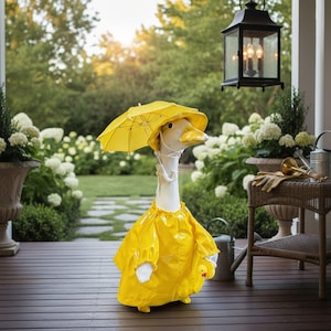 May include: A whimsical goose statue dressed in a bright yellow raincoat and matching hat, complete with a small yellow umbrella. The goose is holding a small yellow duck. The statue is set on a wooden deck with a garden backdrop.