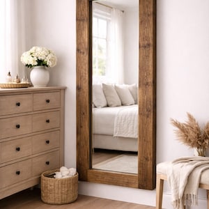 Large rustic reclaimed wood mirror styled in multiple interiors including bedroom, bathroom and living room.