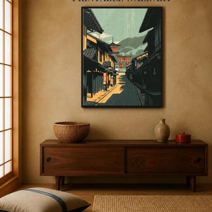May include: A framed wall art print featuring a stylized illustration of a narrow street lined with dark wooden buildings, leading toward a distant red torii gate and mountains under a pale sky. The text INSTANT DOWNLOAD PRINTABLE WALL ART appears above.