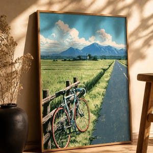 Japanese wall art poster of a bicycle and rice fields leaning against white bookshelves in a bright home interior
