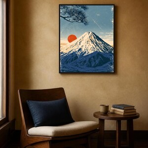 May include: A framed wall art print featuring a stylised illustration of a snow-capped mountain peak under a blue sky with a large red sun and a pine tree branch in the upper corner, rendered in a textured, vintage-inspired graphic art style.