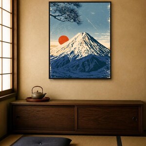 May include: A framed wall art print depicting a snow-capped mountain peak under a blue sky with a prominent red sun and a pine tree branch in the upper corner. The artwork features a textured, weathered aesthetic with deep blue and white tones.