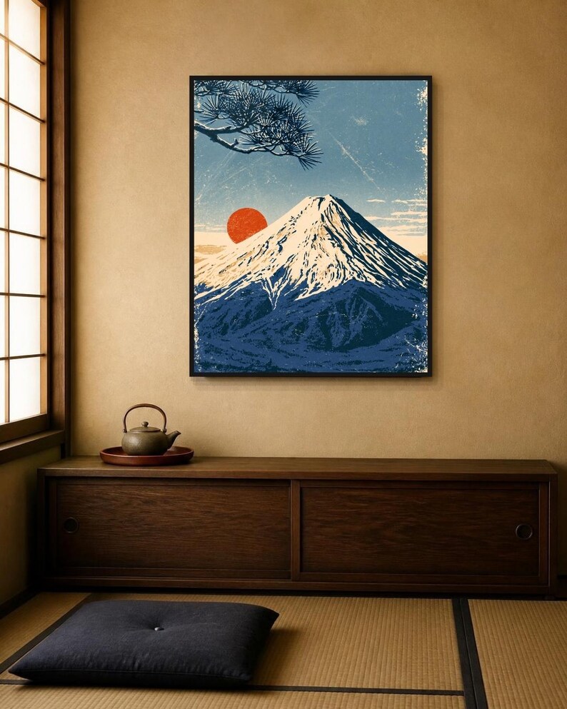May include: A framed wall art print depicting a snow-capped mountain peak under a blue sky with a prominent red sun and a pine tree branch in the upper corner. The artwork features a textured, weathered aesthetic with deep blue and white tones.