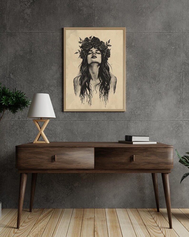 May include: A framed wall art print featuring a black ink illustration of a person with long hair and a crown of roses on their head. The person has their head tilted back with eyes closed, and the ink appears to drip down from the hair.