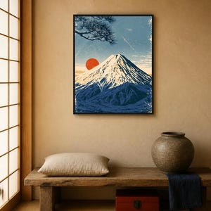 May include: A framed wall art print featuring a stylised illustration of a snow-capped mountain peak under a blue sky with a prominent red sun and a pine tree branch in the upper corner, rendered in a textured, vintage-inspired graphic art style.