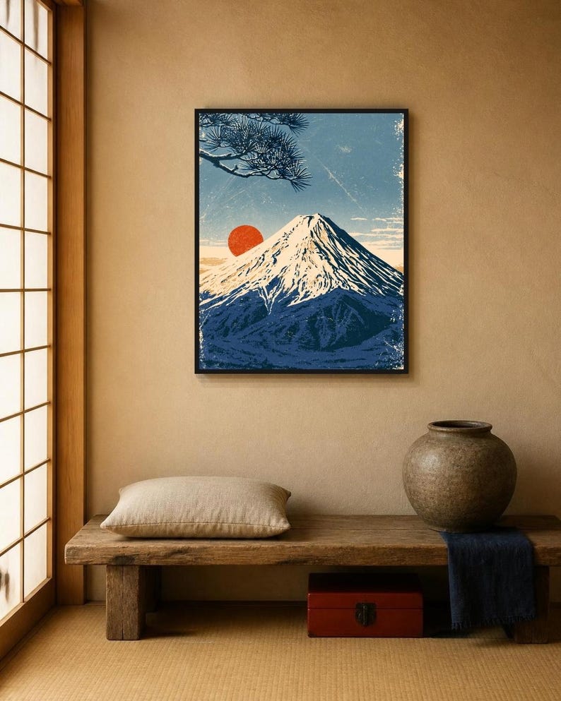 May include: A framed wall art print featuring a stylised illustration of a snow-capped mountain peak under a blue sky with a prominent red sun and a pine tree branch in the upper corner, rendered in a textured, vintage-inspired graphic art style.