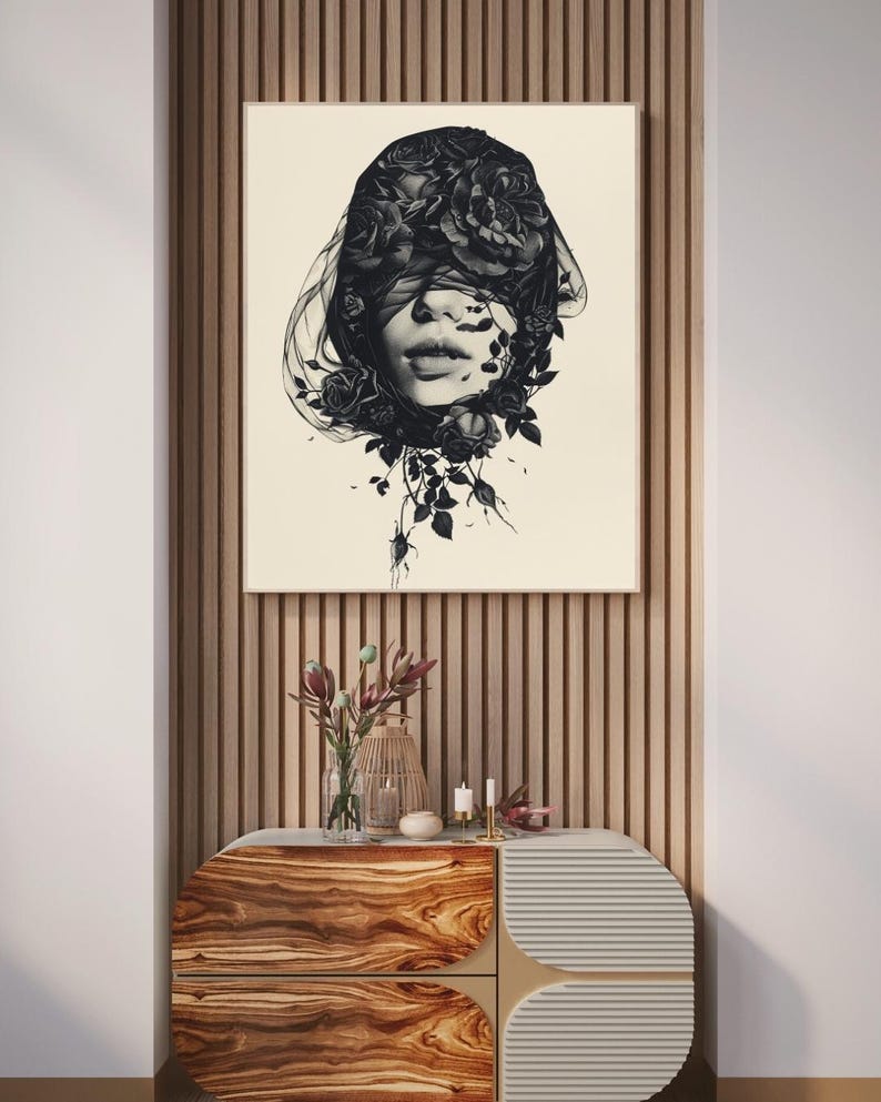 Op de afbeelding: Een vierkante wandkunstprint met een zwart-witillustratie van een gezicht dat gedeeltelijk wordt bedekt door een donkere sluier en bloeiende rozen. Het kunstwerk staat op een cr&egrave;mekleurige achtergrond in een dunne houten lijst.
