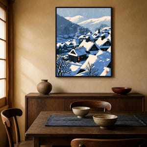 May include: A framed wall art print depicting a snowy village scene with dark-roofed houses covered in thick white snow, bare trees, and distant mountains under a pale blue sky. A single red lantern glows near a house, and a small red seal is visible.