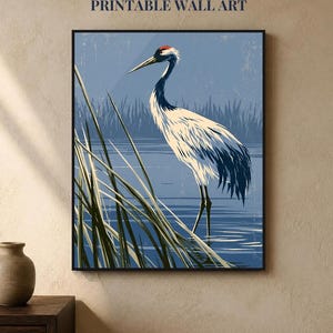 May include: A framed wall art print featuring a red-crowned crane standing in blue water among tall green reeds. The text INSTANT DOWNLOAD PRINTABLE WALL ART is displayed above the illustration, which has a distressed, textured appearance.